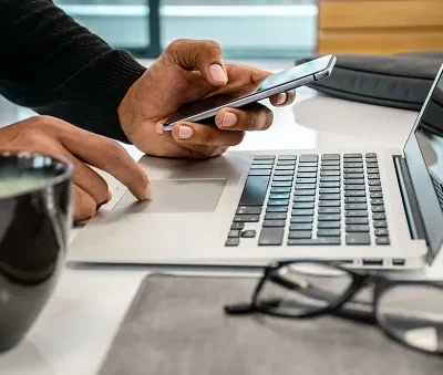 close up photo of men using phone and laptop