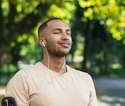 close up portrait of sportsman in park hispanic man jogging in park with eyes closed