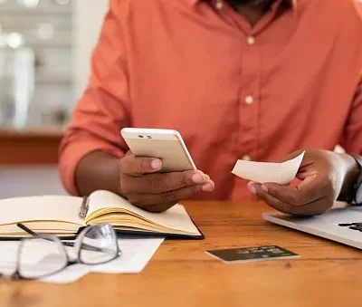 man hands using smartphone and holding receipt