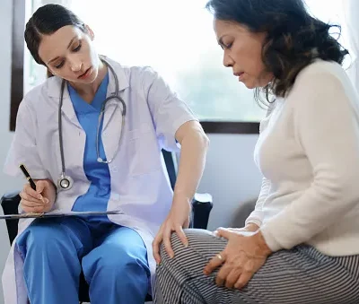 portrait of a female doctor talking to a patient with knee pain