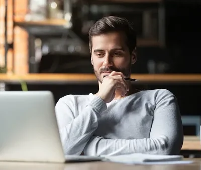 thoughtful businessman think of online project looking at laptop