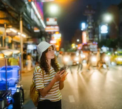 woman using smartphone while exploring chinatown in bangkok during vacation